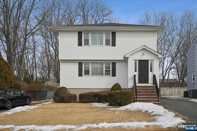 colonial-style house with entry steps and fence