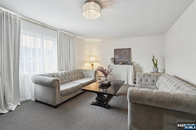 living area with carpet and a notable chandelier