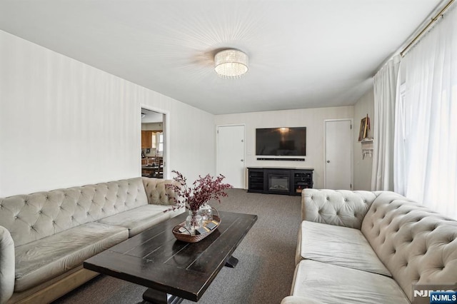 carpeted living room featuring a wealth of natural light and a glass covered fireplace