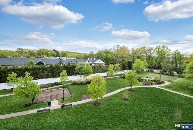 view of property's community featuring a yard and fence