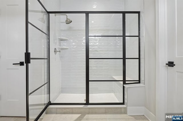 full bathroom featuring a shower stall and baseboards