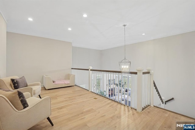 sitting room featuring a notable chandelier, crown molding, wood finished floors, and recessed lighting