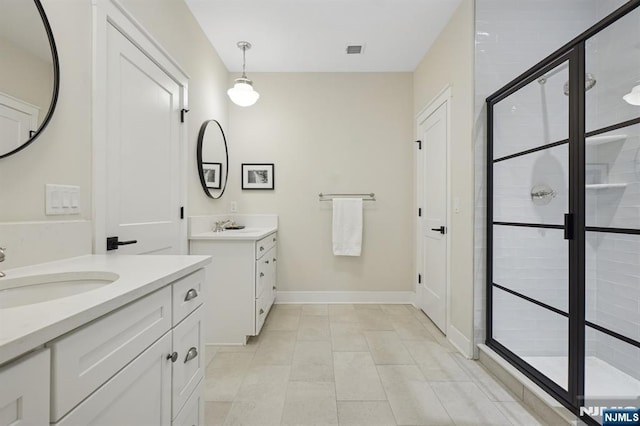 full bathroom with two vanities, visible vents, a stall shower, a sink, and baseboards