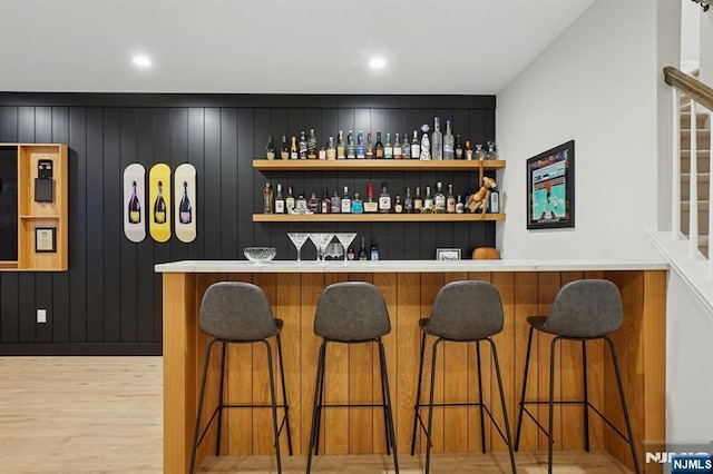 bar featuring bar area and light wood finished floors