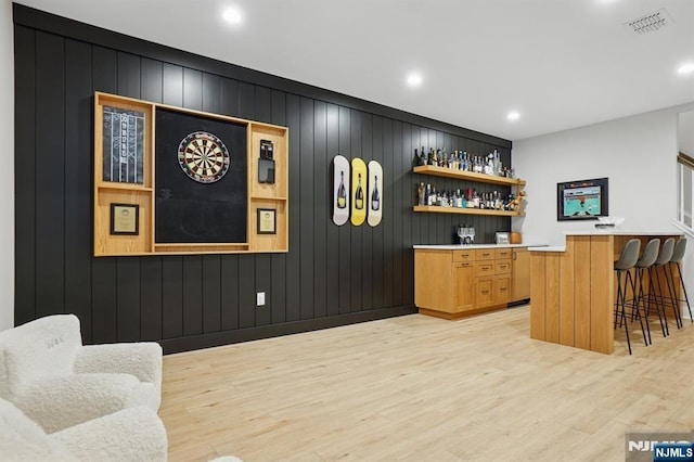 bar featuring a bar, light wood-style floors, visible vents, and recessed lighting