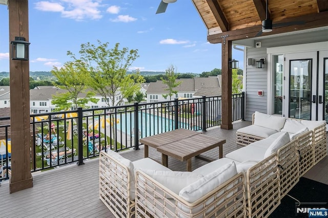 wooden terrace with a ceiling fan, a residential view, and an outdoor hangout area