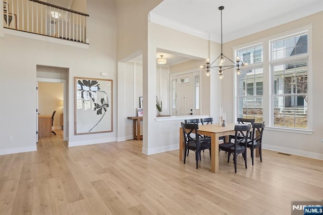 dining space with visible vents, baseboards, light wood-style flooring, ornamental molding, and an inviting chandelier