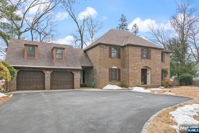 view of front of property with driveway and brick siding