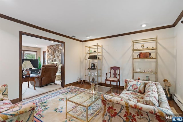 living area with baseboards, visible vents, a baseboard radiator, ornamental molding, and wood finished floors