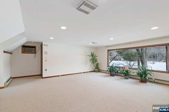 unfurnished room with light carpet, visible vents, a wall unit AC, a baseboard radiator, and a healthy amount of sunlight