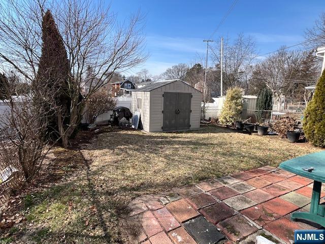 view of yard featuring a patio area, a shed, an outdoor structure, and a fenced backyard