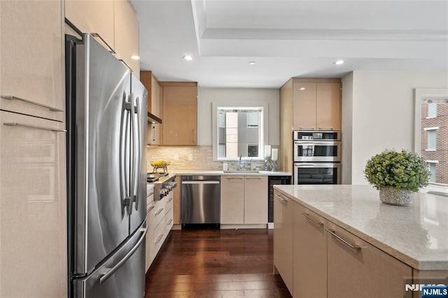 kitchen with light brown cabinetry, appliances with stainless steel finishes, and backsplash