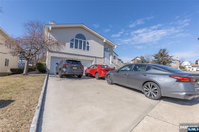 exterior space with a residential view, driveway, and an attached garage