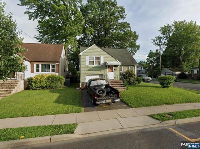 split level home featuring an attached garage, central AC, and a front yard