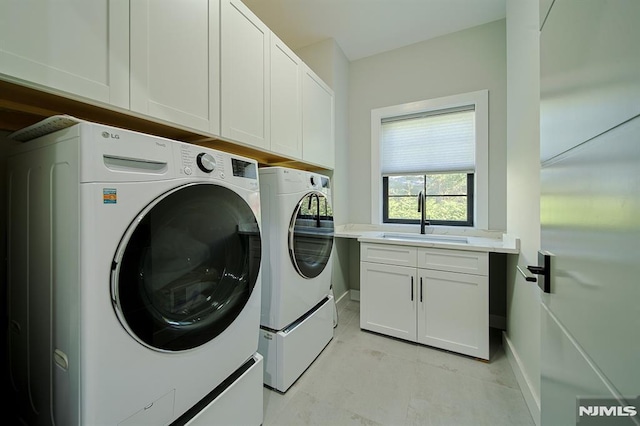 laundry room featuring washer and clothes dryer, cabinet space, baseboards, and a sink