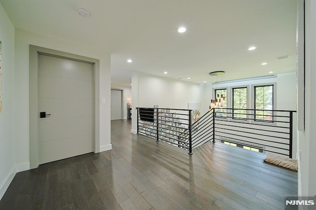 spare room featuring recessed lighting, dark wood-type flooring, and baseboards