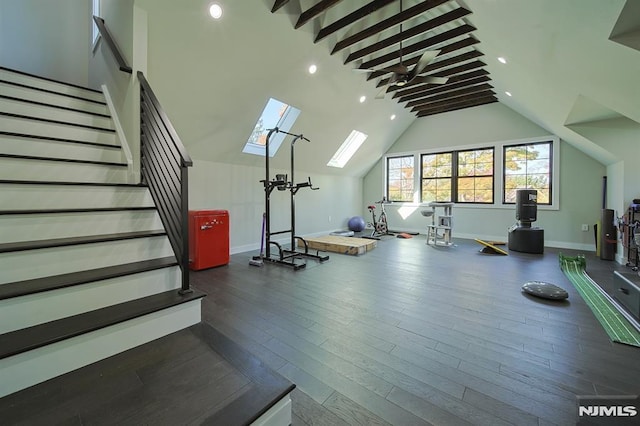 workout room featuring wood finished floors, baseboards, high vaulted ceiling, a skylight, and recessed lighting