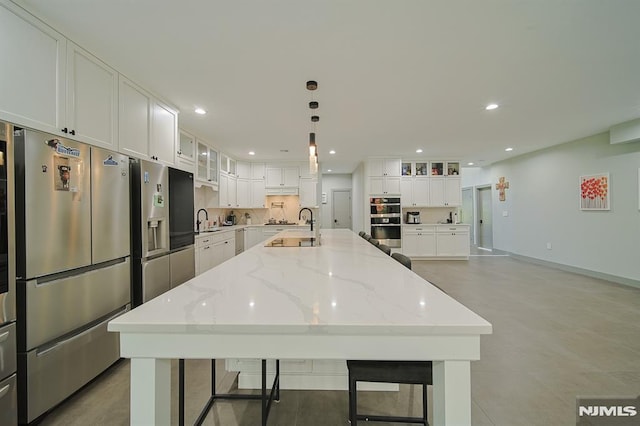 kitchen with a sink, a large island, recessed lighting, and stainless steel appliances