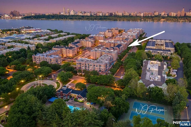 aerial view at dusk with a water view and a city view