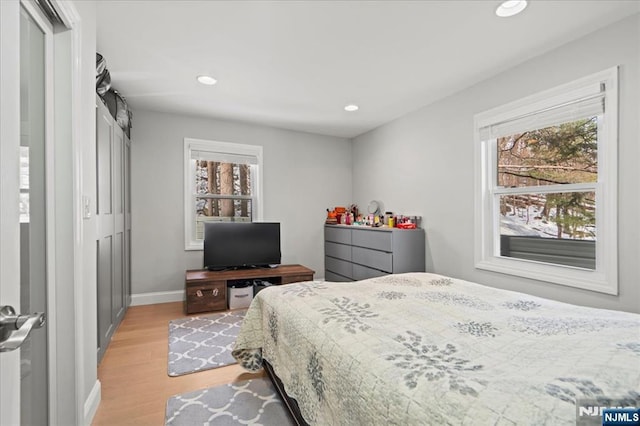 bedroom featuring light wood-type flooring, multiple windows, and recessed lighting