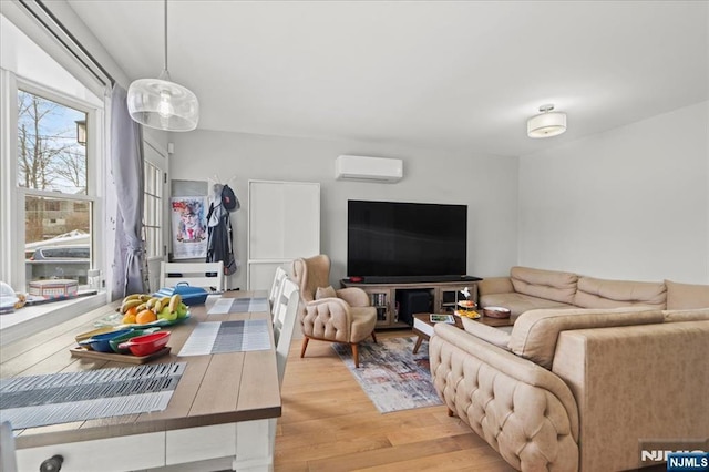 living area featuring a wall mounted AC and light wood-type flooring