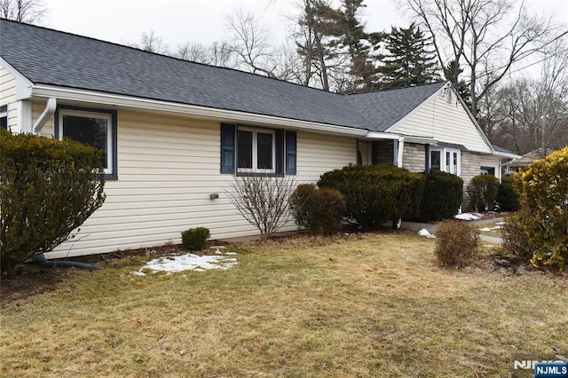 view of home's exterior featuring a yard and roof with shingles