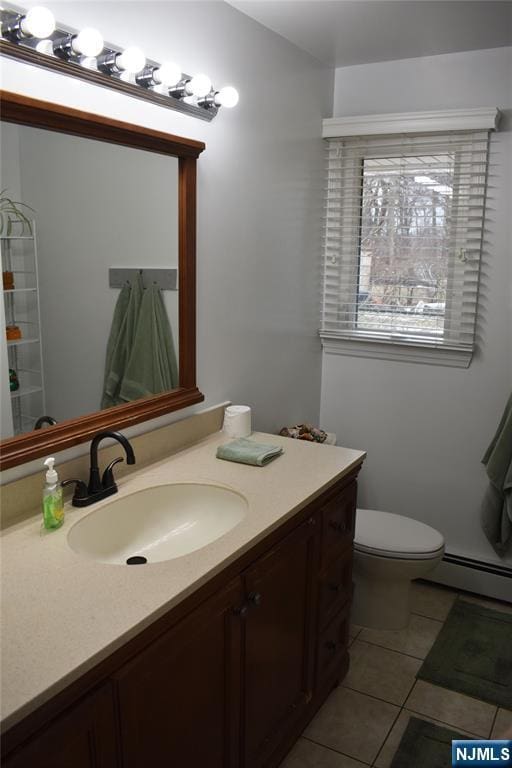 bathroom featuring toilet, a baseboard radiator, tile patterned flooring, and vanity