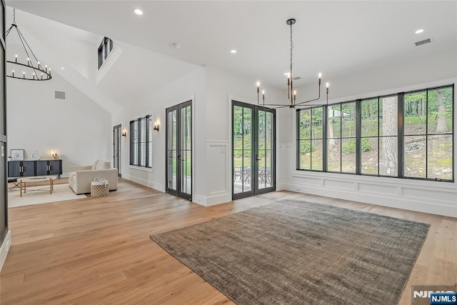 interior space featuring visible vents, a decorative wall, recessed lighting, light wood-style floors, and a notable chandelier