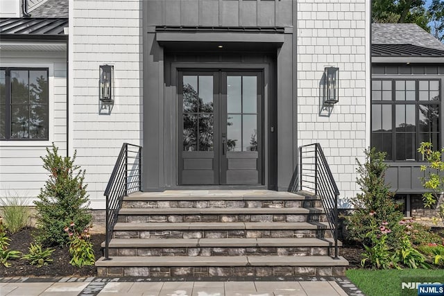 doorway to property with french doors, roof with shingles, and a standing seam roof