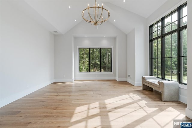 unfurnished room with baseboards, a chandelier, light wood-type flooring, recessed lighting, and high vaulted ceiling