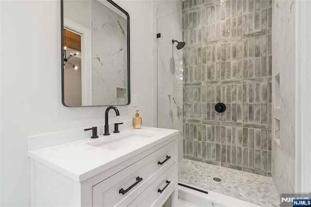 full bathroom featuring vanity and tiled shower