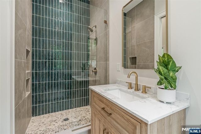 full bathroom with vanity and a tile shower