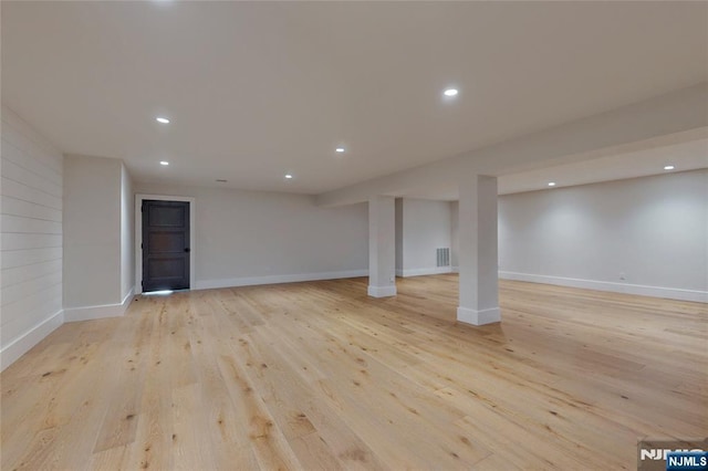 finished below grade area with recessed lighting, visible vents, light wood finished floors, and baseboards