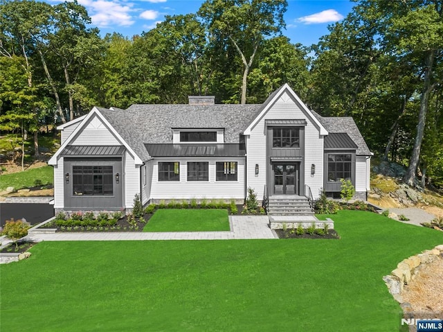 view of front of home with a standing seam roof, a front lawn, and metal roof