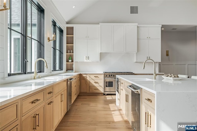 kitchen with lofted ceiling, a healthy amount of sunlight, visible vents, and a sink