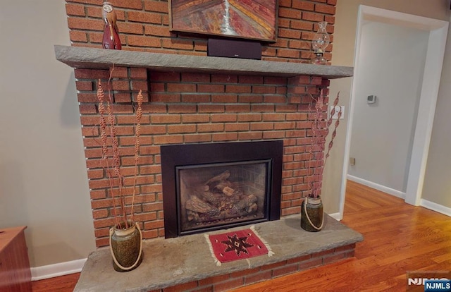 30 Brookvale Rd, Kinnelon Borough, NJ 07405 - detailed view of a brick fireplace, baseboards, and wood finished floors