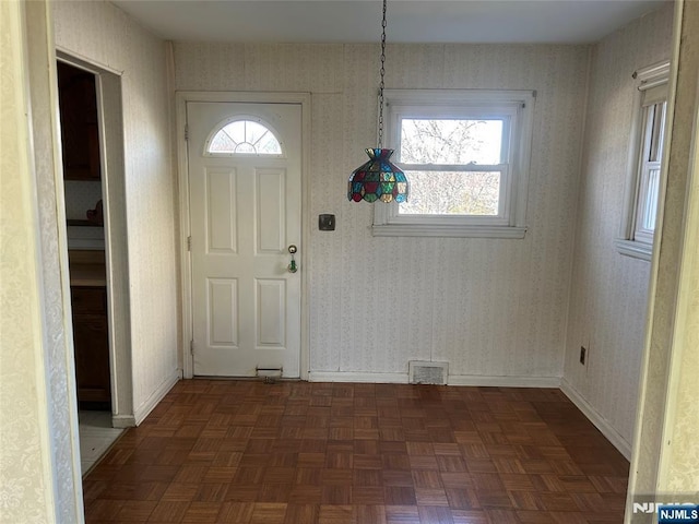 entryway with visible vents, baseboards, and wallpapered walls