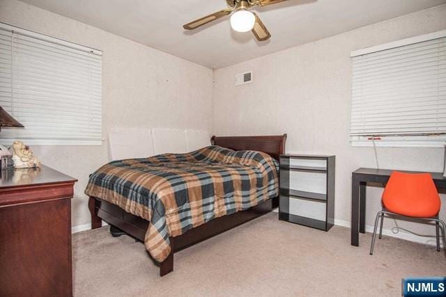 bedroom with baseboards, ceiling fan, visible vents, and carpet flooring