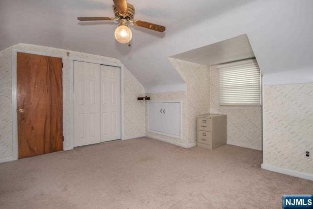 bonus room with lofted ceiling, ceiling fan, and carpet