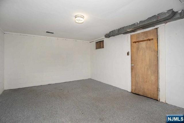 empty room with carpet floors and concrete block wall