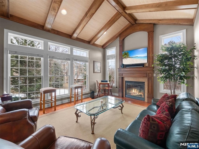 sunroom / solarium with vaulted ceiling with beams, wooden ceiling, and a fireplace