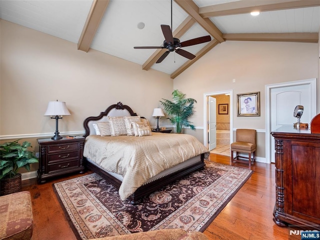 bedroom with lofted ceiling with beams, ensuite bath, wood finished floors, and baseboards