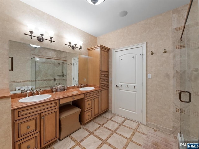 full bathroom featuring double vanity, a sink, and a shower stall