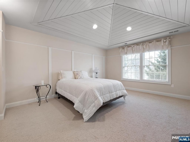 carpeted bedroom with vaulted ceiling, visible vents, and baseboards