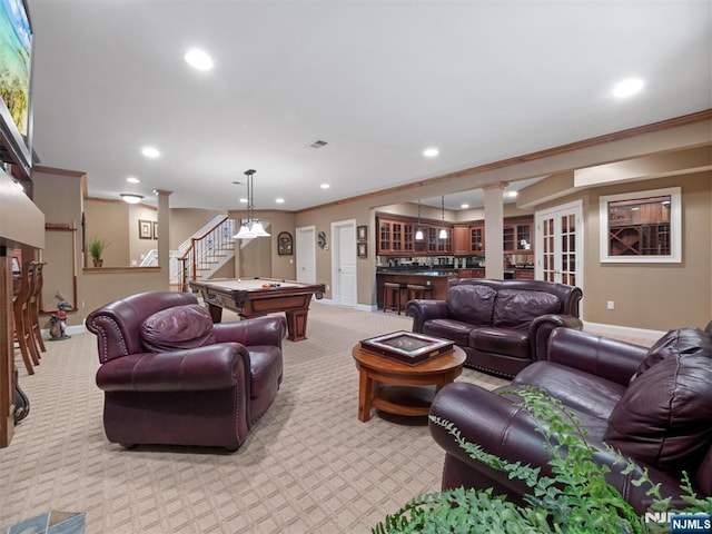 living room with ornamental molding, bar area, light carpet, and stairs