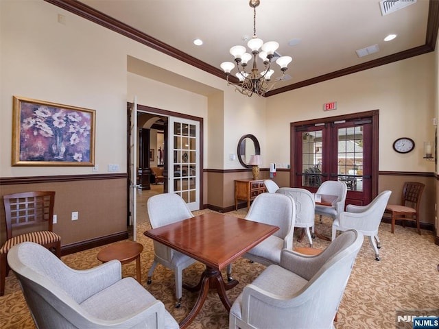 living area featuring a wainscoted wall, french doors, and visible vents