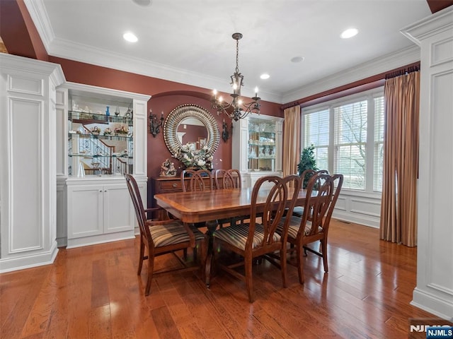 dining area with ornamental molding, a decorative wall, and hardwood / wood-style floors