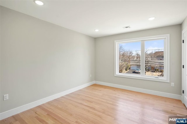 spare room with recessed lighting, light wood-type flooring, visible vents, and baseboards