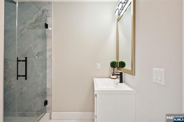 bathroom featuring a stall shower, vanity, and baseboards