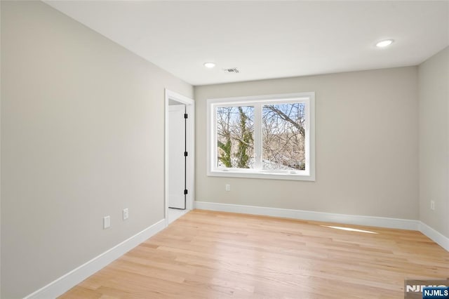 spare room with light wood finished floors, recessed lighting, visible vents, and baseboards